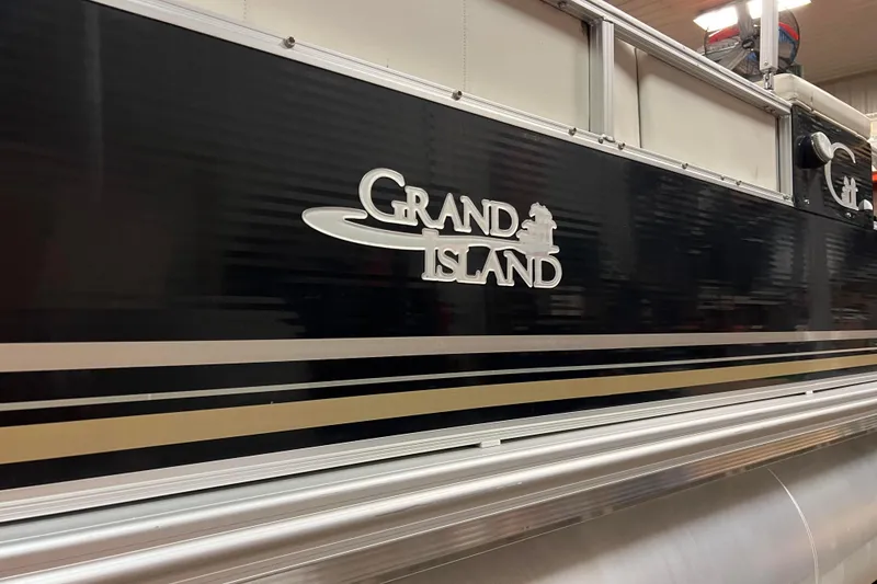 Slide: The Image of 2014 Avalon Grand Island 2485 QF pontoon boat with sleek black and gold design. - 30