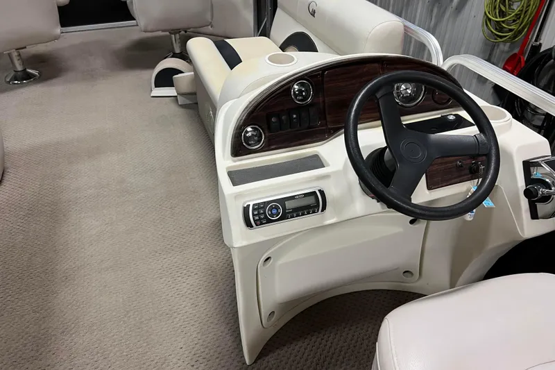 Slide: The Image of 2014 Avalon Grand Island 2485 QF boat interior with steering wheel and dashboard controls. - 52