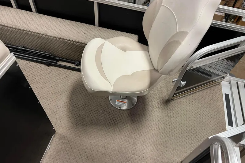 Slide: The Image of 2014 Avalon Grand Island 2485 QF boat interior with swivel seat and carpeted floor. - 64