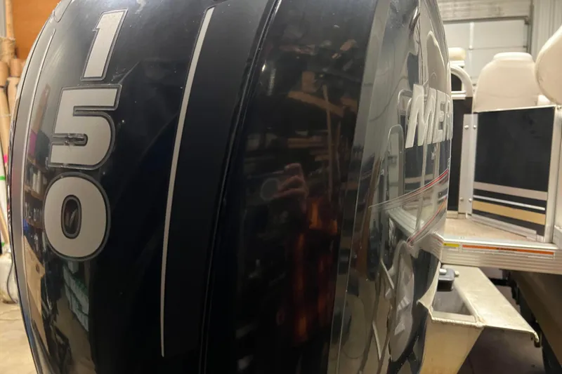 Slide: The Image of 2014 Avalon Grand Island 2485 QF with Mercury 150 outboard motor in a garage setting. - 70