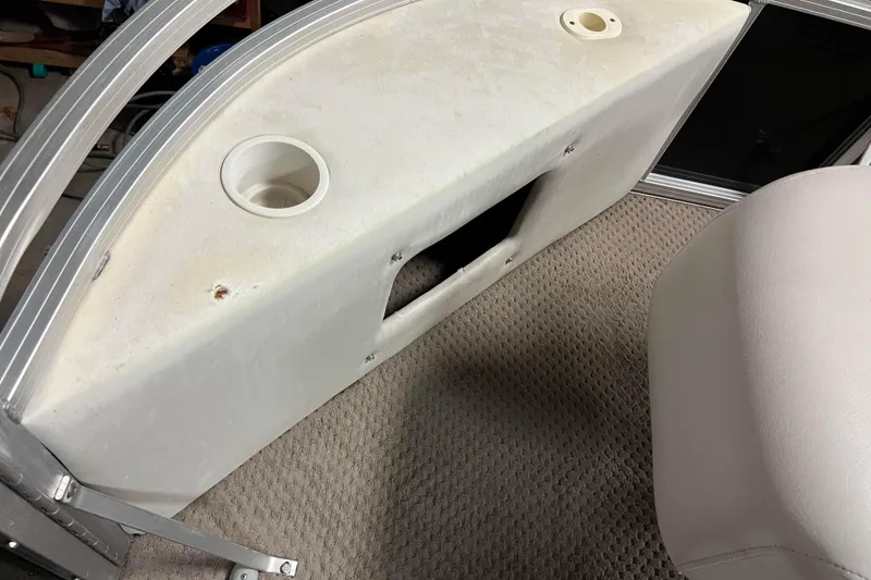 Slide: The Image of 2014 Avalon Grand Island 2485 QF boat interior with storage compartment and cup holder. - 9