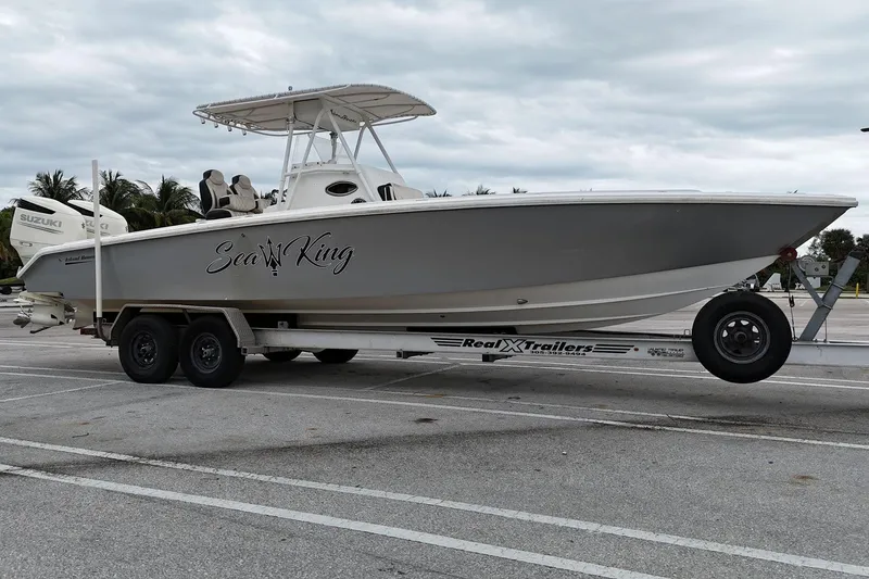 The Image of 2002 Island Runner 31 boat on trailer, labeled "Sea King," parked in a lot. - 1