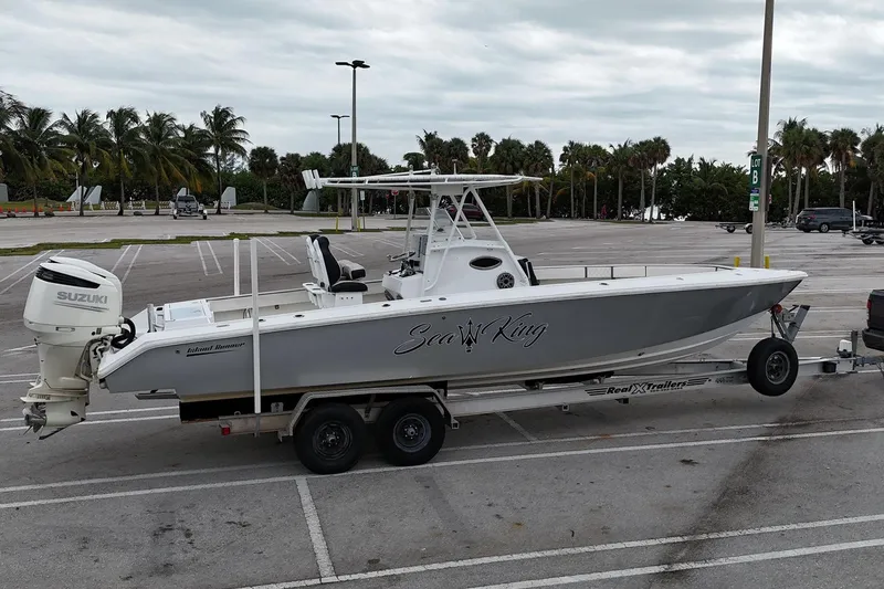 Slide: The Image of 2002 Island Runner 31 boat on trailer in parking lot with palm trees. - 3