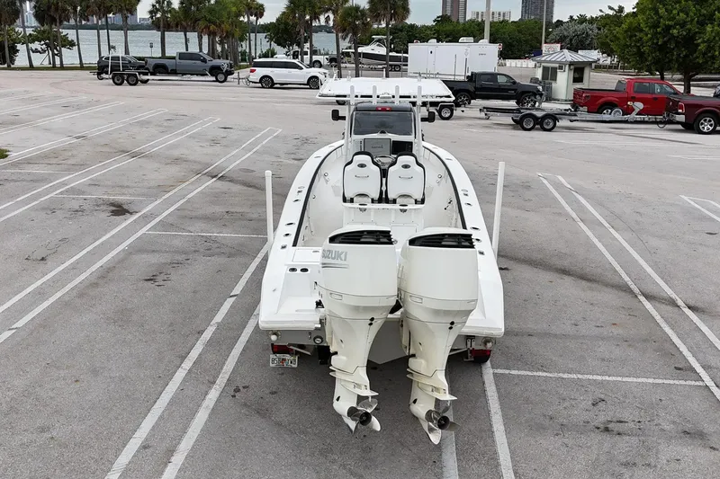 Slide: The Image of 2002 Island Runner 31 boat with dual Suzuki engines in a parking lot near water. - 8