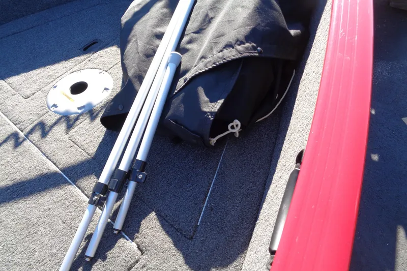 Slide: The Image of 2022 Lund 1650 Rebel XL SS boat interior with poles and black bag. - 14