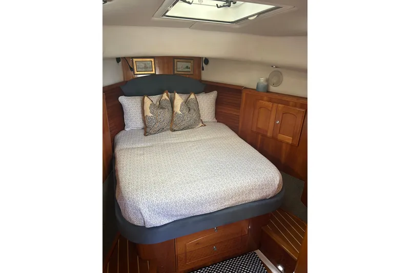 Slide: The Image of Cozy cabin interior of 2007 Legacy Yachts 32 Express with elegant bedding and wood finish. - 5