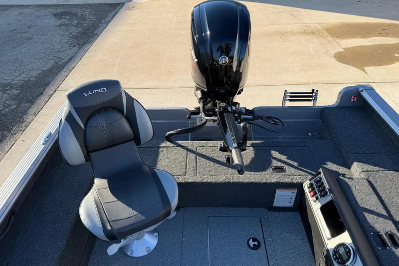 Slide: The Image of 2026 Lund 1875 Pro Guide boat interior with seat and motor, showcasing modern design. - 20