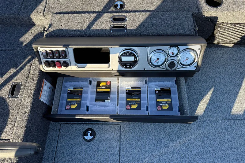 Slide: The Image of 2026 Lund 1875 Pro Guide boat dashboard with storage compartments and control panel. - 23
