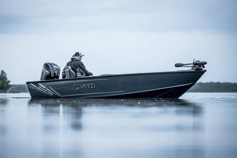 Slide: The Image of 2026 Lund 1875 Pro Guide boat with Mercury engine, parked outdoors. - 5