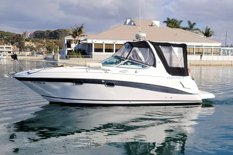 The Image of 2005 Four Winns 268 Vista boat on calm water near a marina. - 0