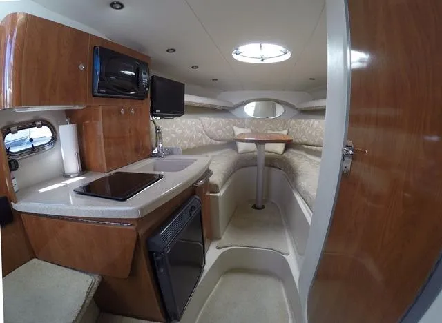 Slide: The Image of 2005 Four Winns 268 Vista cabin interior with kitchenette, seating area, and modern amenities. - 19