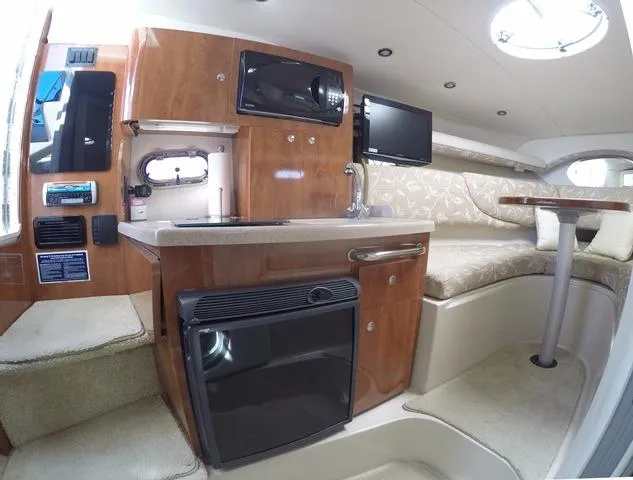 Slide: The Image of 2005 Four Winns 268 Vista cabin interior with kitchenette, seating, and modern amenities. - 20
