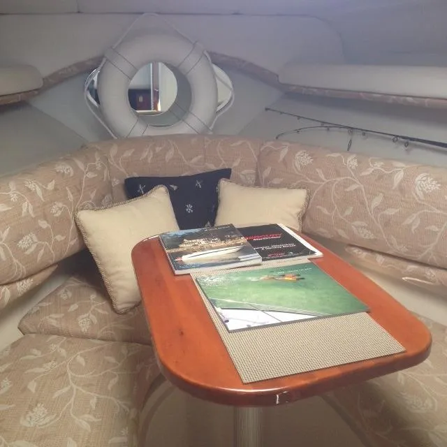 Slide: The Image of Interior of 2005 Four Winns 268 Vista boat with cozy seating and wooden table. - 23