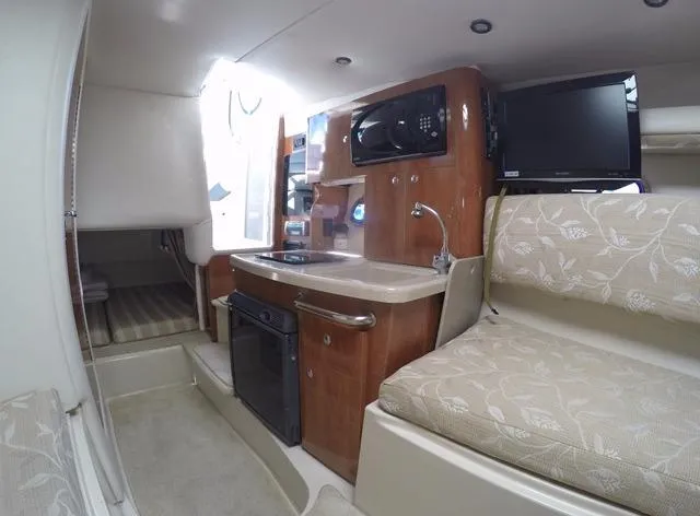 Slide: The Image of 2005 Four Winns 268 Vista cabin interior with kitchenette, seating, and modern amenities. - 24