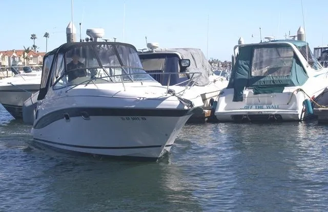 Slide: The Image of 2005 Four Winns 268 Vista boat docked in a marina, surrounded by other vessels. - 28