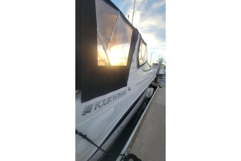 Slide: The Image of 2005 Four Winns 268 Vista boat docked at sunset, showcasing sleek design. - 31