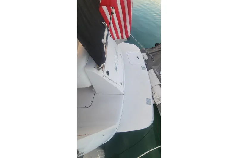Slide: The Image of 2005 Four Winns 268 Vista boat stern with American flag, docked on calm water. - 6