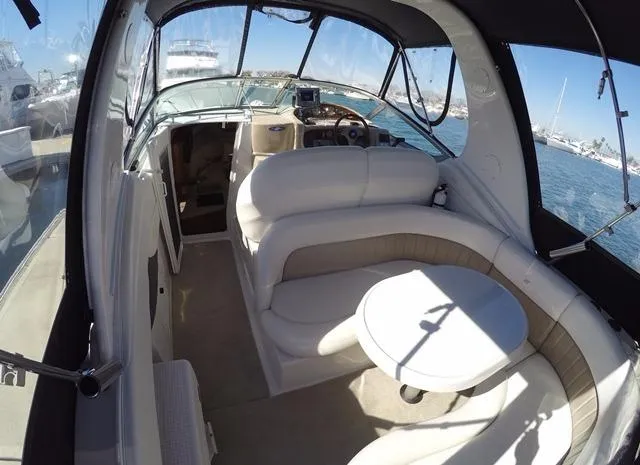 Slide: The Image of 2005 Four Winns 268 Vista boat interior with seating and table, docked in a marina. - 9