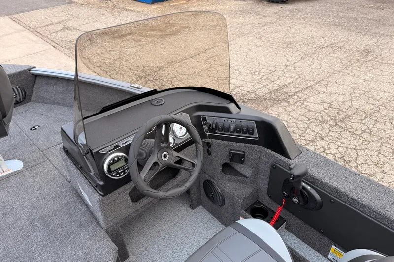 Slide: The Image of 2026 Lund 1775 Impact XS SS boat dashboard with steering wheel and controls. - 17