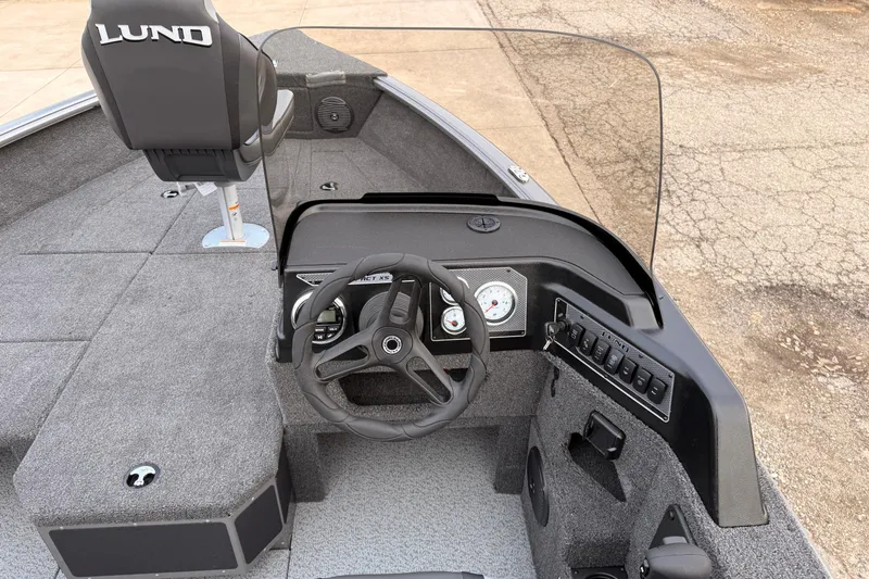 Slide: The Image of 2026 Lund 1775 Impact XS SS boat interior with steering wheel and dashboard controls. - 18