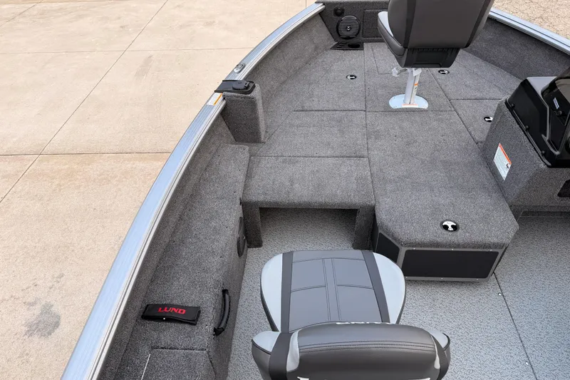 Slide: The Image of 2026 Lund 1775 Impact XS SS boat interior with gray seating and carpeted deck. - 22