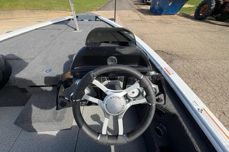 Slide: The Image of 2026 Lund 1875 Pro-V Bass XS boat dashboard with steering wheel and gauges. - 21
