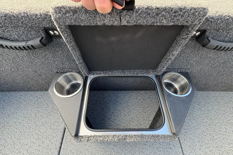 Slide: The Image of 2026 Lund 1875 Pro-V Bass XS boat storage compartment with cup holders and carpeted interior. - 25