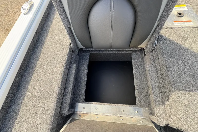 Slide: The Image of 2026 Lund 1875 Pro-V Bass XS boat storage compartment with gray upholstery and carpeted interior. - 28