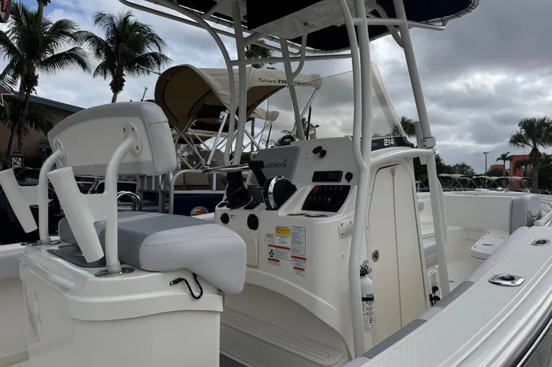 Slide: The Image of 2024 Mako 214 Center Console boat with modern helm and seating, docked under cloudy skies. - 4