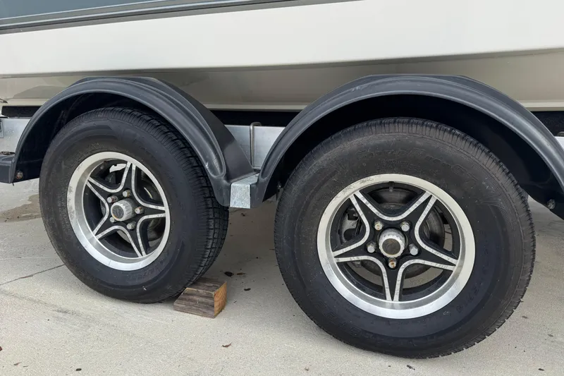 Slide: The Image of Trailer wheels of a 2024 Mako 214 Center Console boat on concrete. - 8