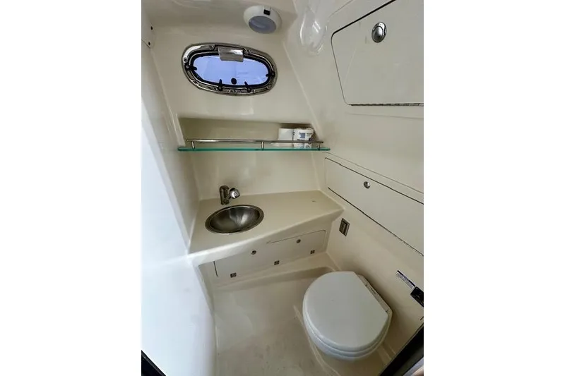 Slide: The Image of 2016 Boston Whaler 285 Conquest boat bathroom with sink, toilet, and storage. - 13