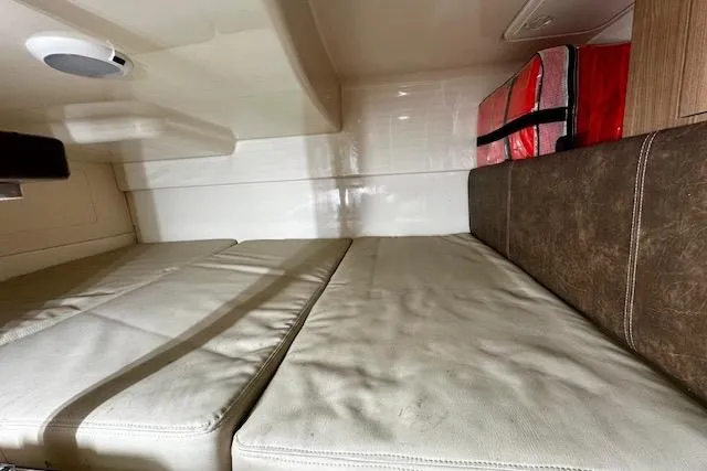 Slide: The Image of Interior cabin of 2016 Boston Whaler 285 Conquest with cushioned seating and storage. - 15