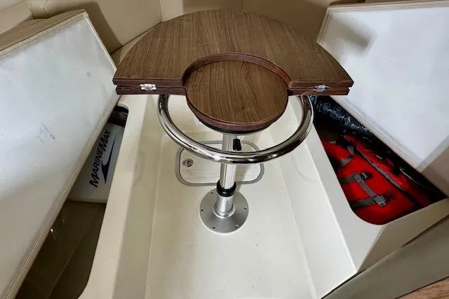 Slide: The Image of 2016 Boston Whaler 285 Conquest interior with wooden table and storage compartments. - 19