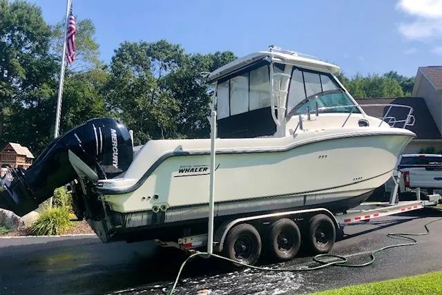 Slide: The Image of 2016 Boston Whaler 285 Conquest boat on trailer, parked outdoors. - 2