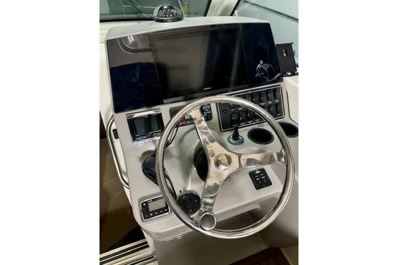 Slide: The Image of 2016 Boston Whaler 285 Conquest helm with steering wheel and navigation controls. - 5