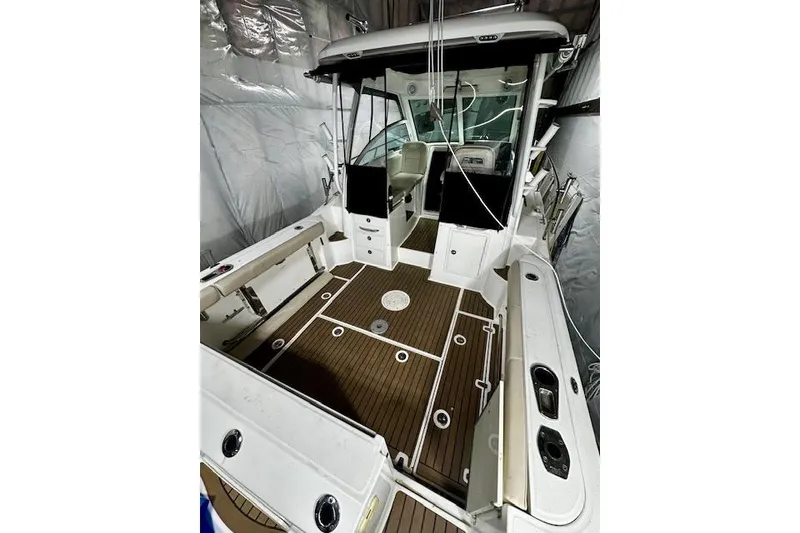 Slide: The Image of 2016 Boston Whaler 285 Conquest boat interior with wood deck and seating. - 6