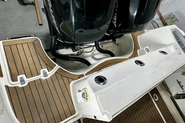 Slide: The Image of 2016 Boston Whaler 285 Conquest boat deck with twin engines and wood-style flooring. - 7
