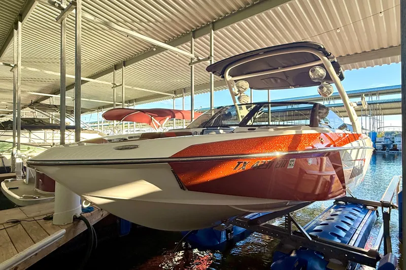 Slide: The Image of 2019 Malibu Wakesetter 23 LSV boat docked under a covered marina. - 10