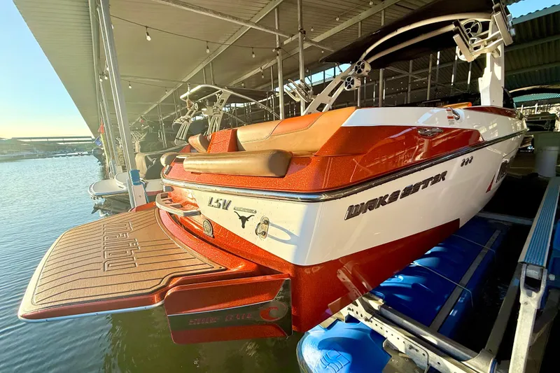 Slide: The Image of 2019 Malibu Wakesetter 23 LSV boat docked, featuring sleek design and vibrant colors. - 13