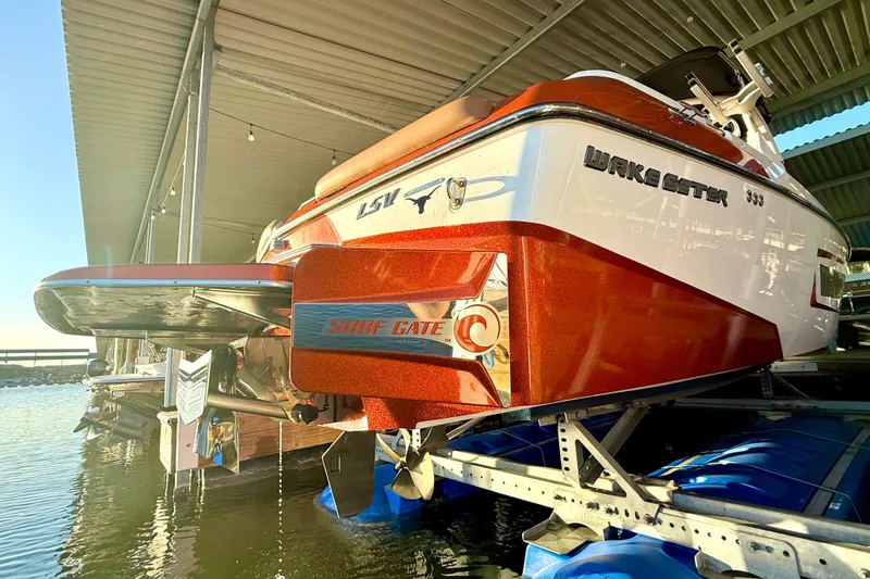 Slide: The Image of 2019 Malibu Wakesetter 23 LSV boat docked, showcasing sleek design and Surf Gate feature. - 14