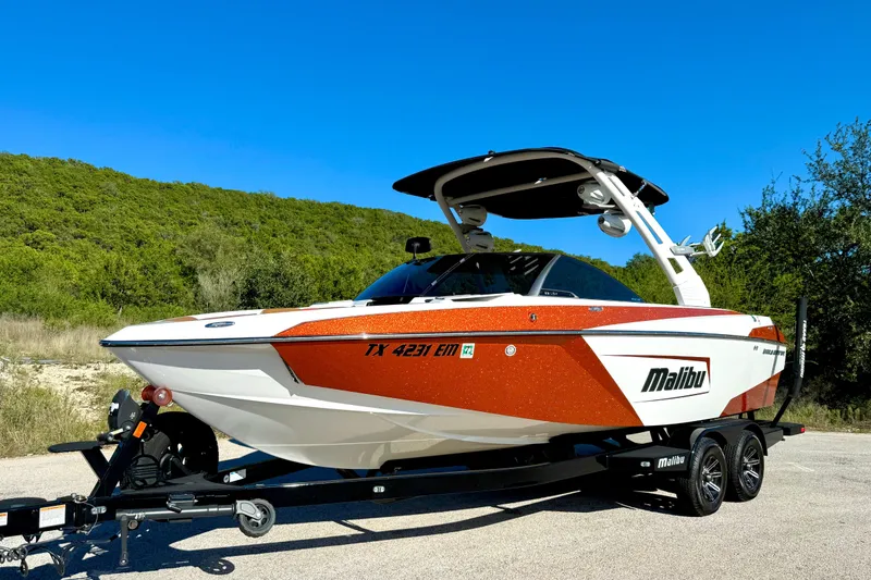 Slide: The Image of 2019 Malibu Wakesetter 23 LSV boat on trailer, vibrant orange and white design. - 18