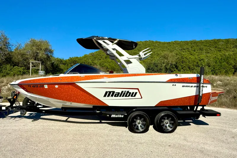Slide: The Image of 2019 Malibu Wakesetter 23 LSV boat on trailer, vibrant orange and white design. - 19