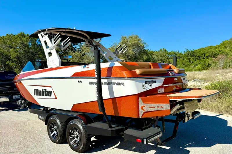 Slide: The Image of 2019 Malibu Wakesetter 23 LSV boat on trailer, vibrant orange and white design. - 20