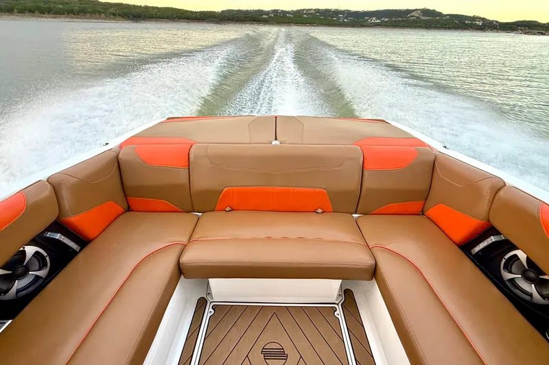 Slide: The Image of 2019 Malibu Wakesetter 23 LSV interior with brown and orange seating on a lake. - 27
