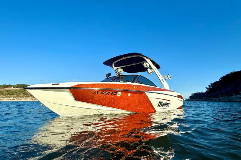 Slide: The Image of 2019 Malibu Wakesetter 23 LSV boat on water under clear blue sky. - 3