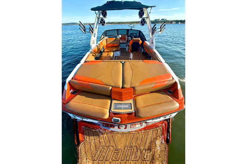 Slide: The Image of 2019 Malibu Wakesetter 23 LSV boat with orange and tan interior on a lake. - 32