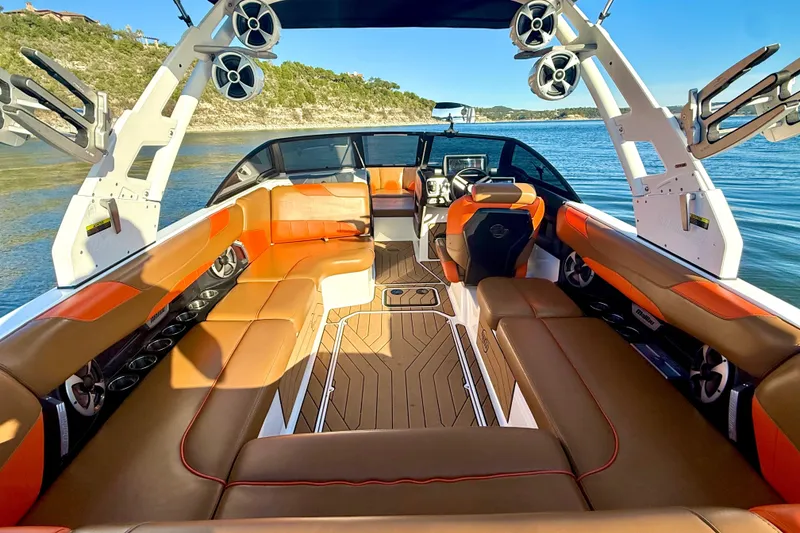 Slide: The Image of 2019 Malibu Wakesetter 23 LSV interior with orange and brown seating on a lake. - 34