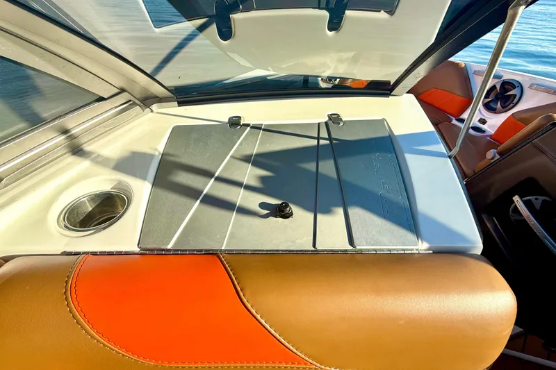 Slide: The Image of 2019 Malibu Wakesetter 23 LSV interior with orange and brown seating, cup holder, and dashboard. - 40