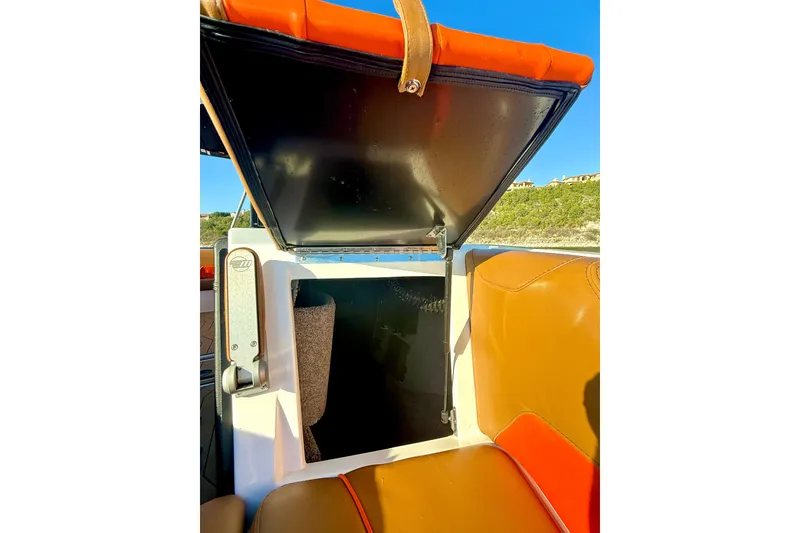 Slide: The Image of 2019 Malibu Wakesetter 23 LSV storage compartment with open hatch, orange and tan seating. - 41
