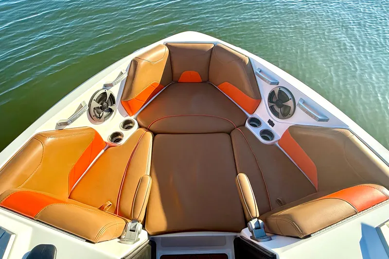Slide: The Image of 2019 Malibu Wakesetter 23 LSV boat interior with brown and orange seating, cup holders, and speakers. - 43